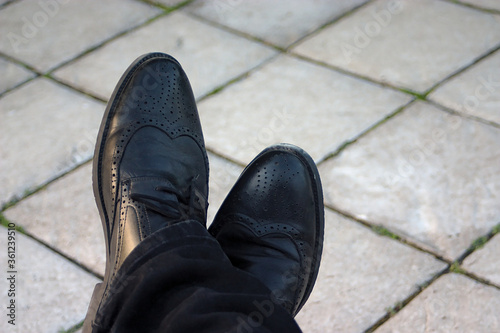 men's feet in black leather shoes
