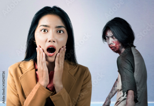Asian businesswoman scared looking at zombies inside the building