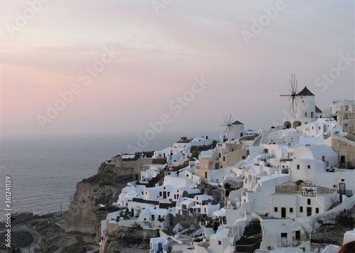Beautiful colorful sunset with one visible windmill on the island of Santorini in Greece from the village of Oia