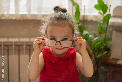 Girl puts on glasses for sight. International Literacy Day. Education and science. Distance learning. Preschool education.