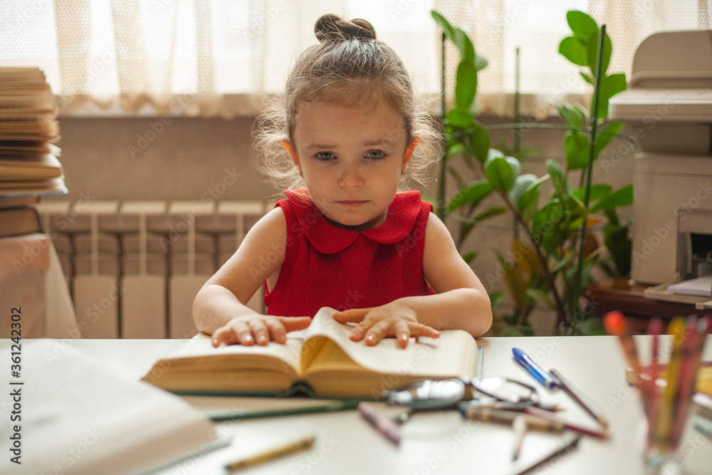 The child is tired of learning. A little girl sits upset and does not want to learn lessons anymore. Preschool education. Education and science. International Literacy Day. The child is tired of learning. A little girl sits upset and does not want to learn lessons anymore. Preschool education. Education and science. International Literacy Day.