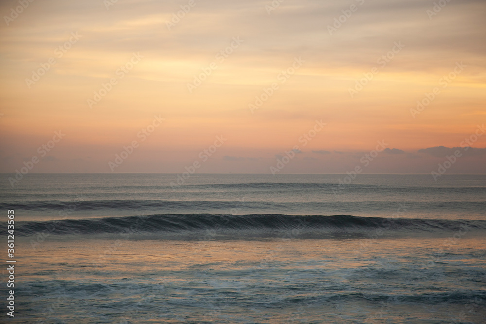 Calming sunset on the beach of  Pantai Lima with isolated glassy ocean wave, Bali Indonesia. 