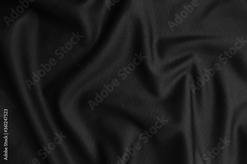 Background texture black cloth. Abstract dark wavy soft. Fabric is wrinkled. Fashion luxury style.