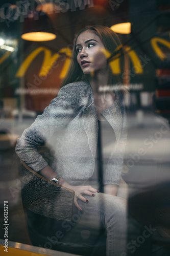 Girl in grey suit posing in cafe with cup of coffee