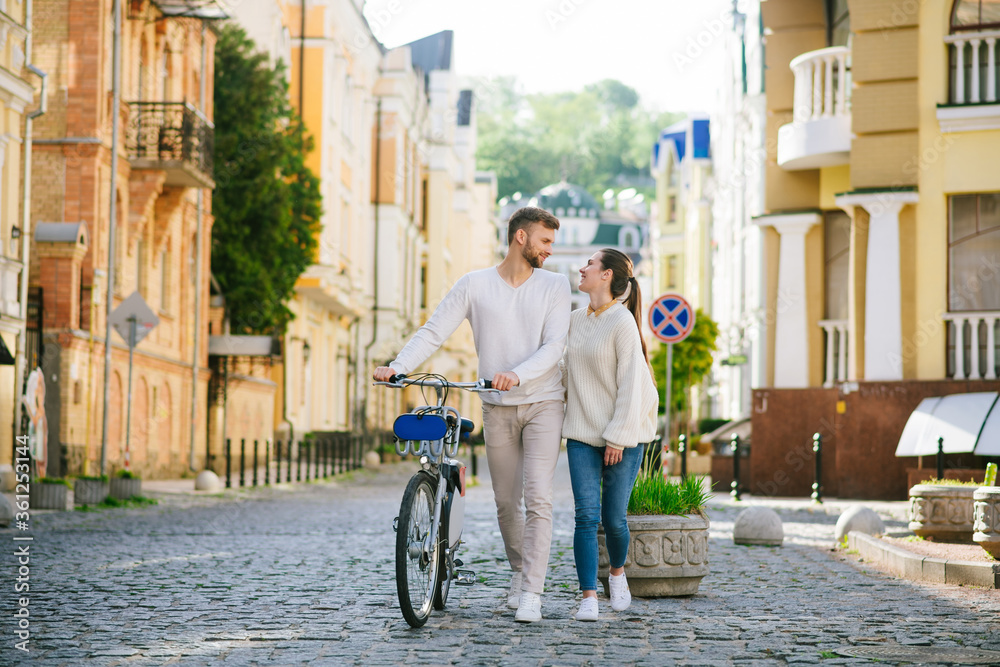 Man with bicycle and woman walking looking at each other