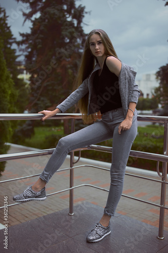 Girl in grey suit posing on the town street