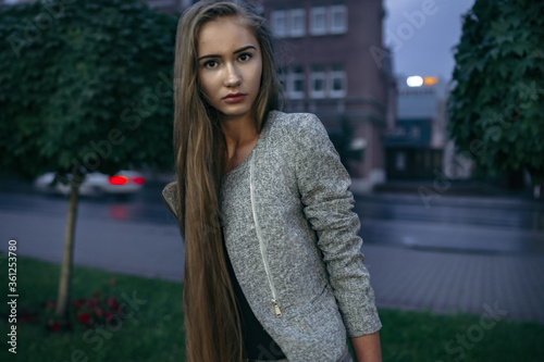 Girl in grey suit posing on the town street