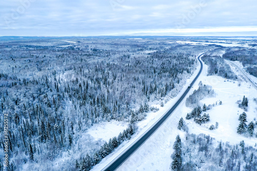 Aerial view on the road and forest at the winter time. Natural winter landscape from air. Forest under snow a the winter time. Landscape from drone © VIK