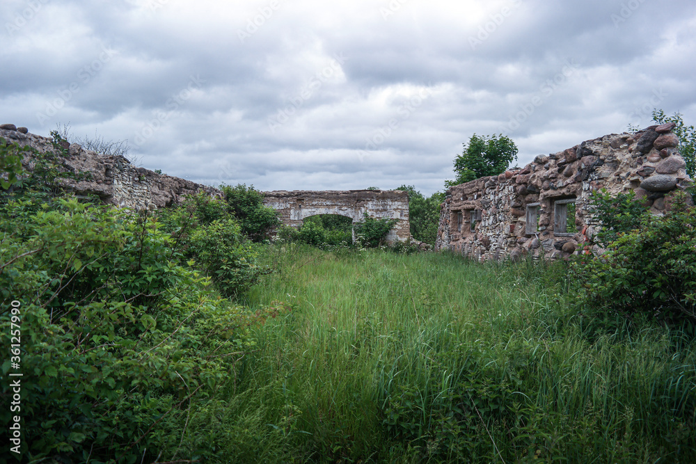 Ruins of old estate buildings made from red brick and stone.