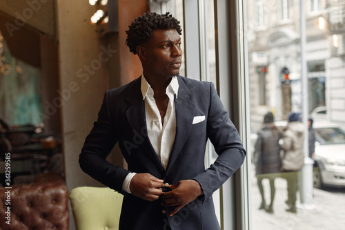 фотографія Black man in a cafe. Man in a black suit.