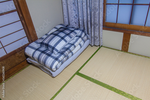 Closeup folded blanket or comforter and pillow on tatami. In traditional japanese culture, people sleep with futon on tatami