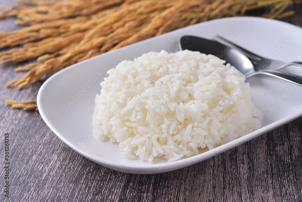Steamed rice, cooked rice in white plate with rice paddy background Steamed rice, cooked rice in white plate with rice paddy background