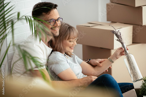 Boyfriend and girlfriend are moving in a apartment. Husband and wife are unpacking their belongins.	 photo