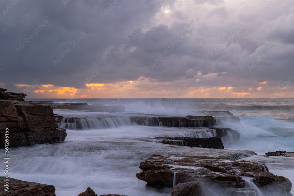 Fototapeta premium Cloudy view of rock formation on the shore.