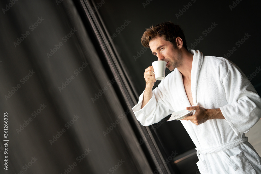 Male in bathrobe relaxing while drinking tea Male in bathrobe relaxing while drinking tea