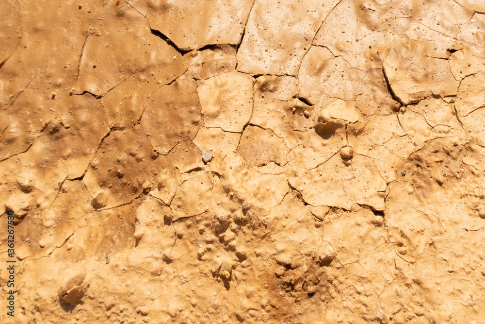 Cracked drought clay ground during the dry season. Bright yellow or orange sand color land with cracks texture. Stock background photo Cracked drought clay ground during the dry season. Bright yellow or orange sand color land with cracks texture. Stock background photo
