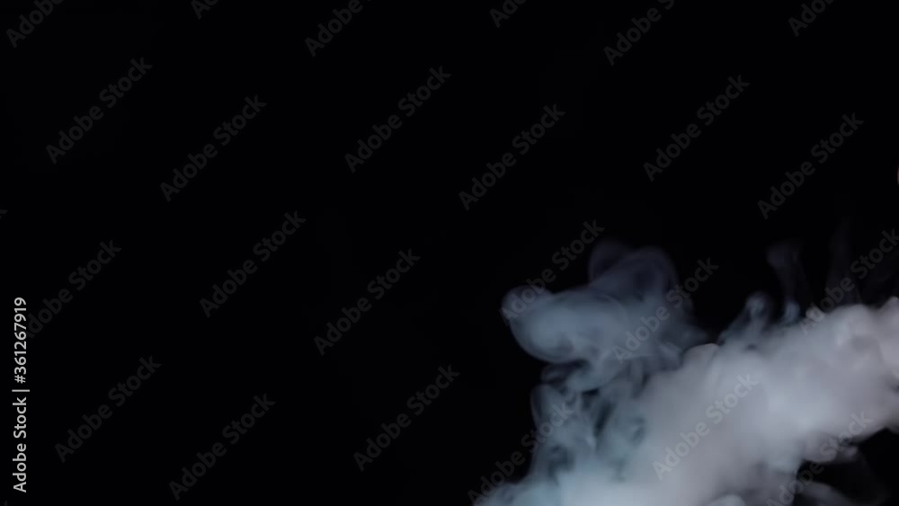 White smoke floating through space against black background. Mist, smoke , vapor, fog effect. Slow motion