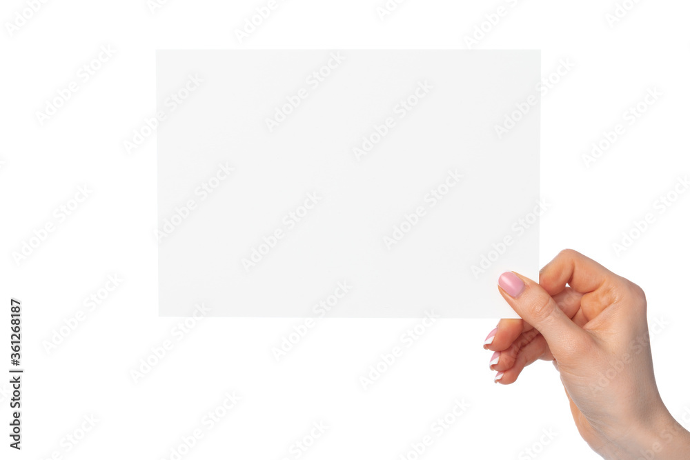 Woman's hand holding blank white sheet of paper isolated on white