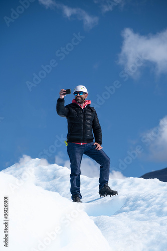 Man taking selfie picture on top of glacier perito moreno 