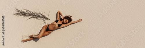 Top Aerial Drone View of Woman in Swimsuit Bikini Relaxing and Sunbathing on Beach photo