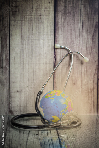 Globe and stethoscope on wooden background, world health day concept