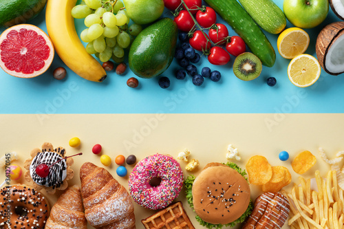 Healthy and unhealthy food background from fruits and vegetables vs fast food, sweets and pastry top view. Diet and detox against calorie and overweight lifestyle concept.