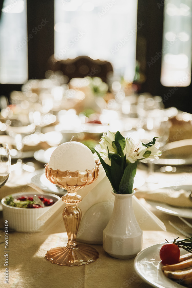 banquet table is decorated with plates, cutlery, glasses, candles and flower arrangements