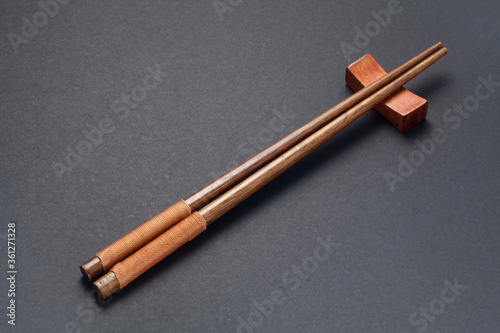 Murais de parede Wooden chopsticks on black paper background