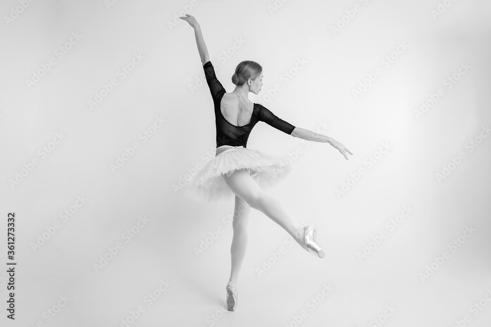 Black and white picture of slender little ballerina dances and enjoys it