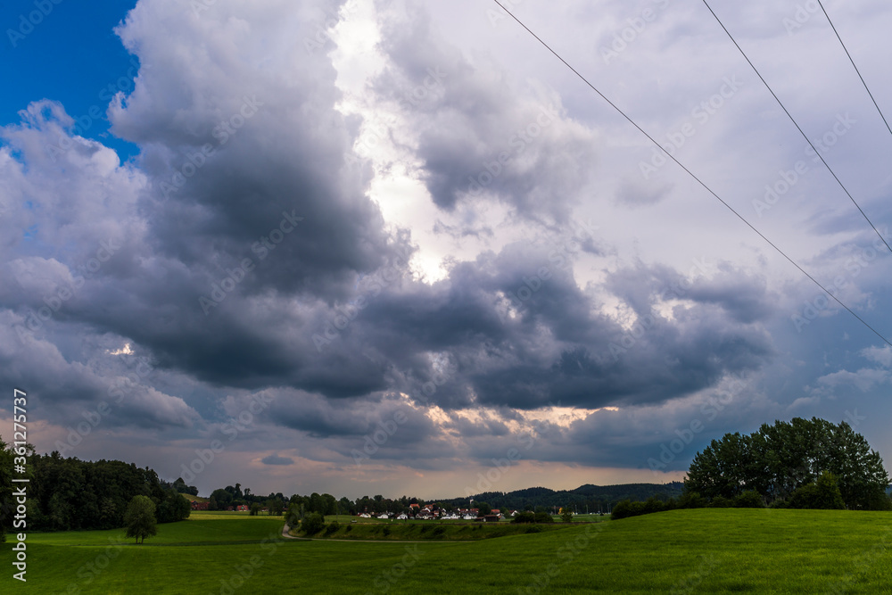 gloomy thunderclouds over a rural area with meadows and forest in the Baden Allgäu near Wolfegg gloomy thunderclouds over a rural area with meadows and forest in the Baden Allgäu near Wolfegg
