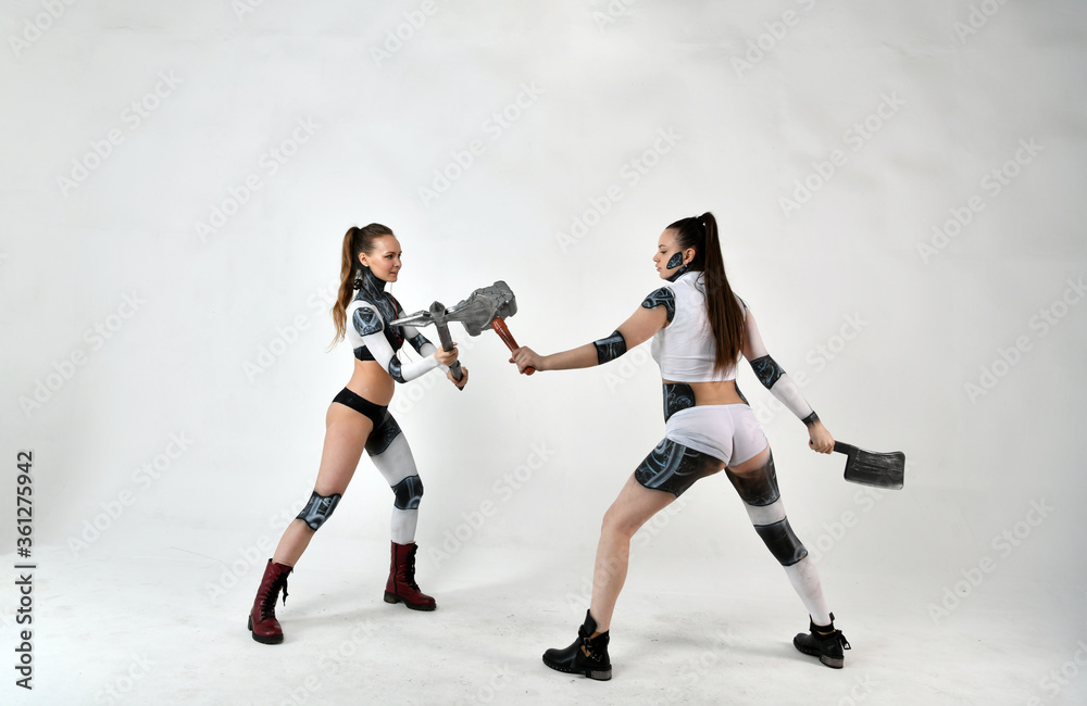 beautiful girls in costumes of robots quarreled and fight with a battle ax and a war hammer beautiful girls in costumes of robots quarreled and fight with a battle ax and a war hammer