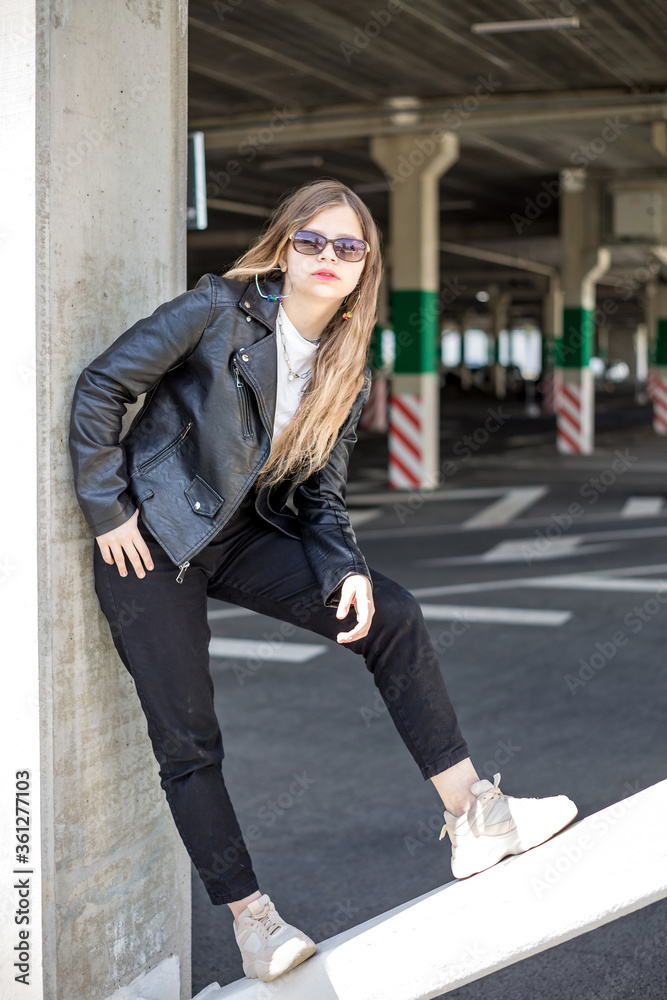 young blonde schoolgirl in black leather jacket posing in the parking lot young blonde schoolgirl in black leather jacket posing in the parking lot