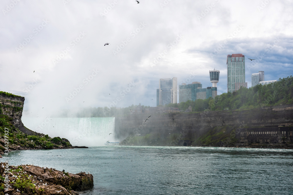 Boat with tourists near waterfall at Niagara falls