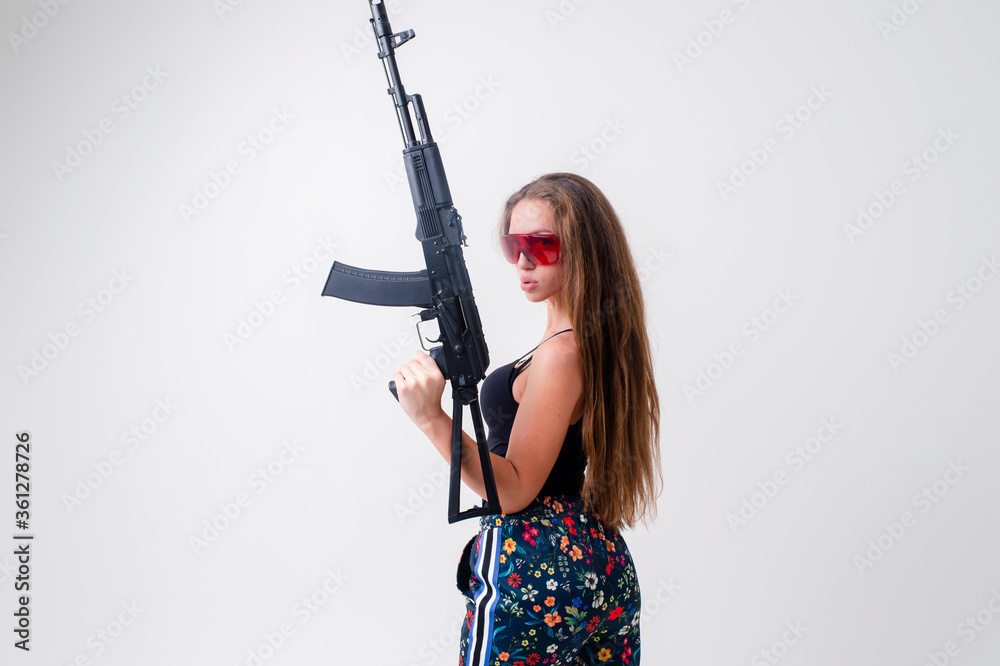 Pretty cyborg girl in boots with machine gun in profile isolated on white backround Pretty cyborg girl in boots with machine gun in profile isolated on white backround