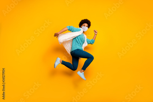 Full length body size view of her she attractive healthy active motivated girl wearing safety mask jumping running marathon stop mers cov infection pandemia isolated bright yellow color background