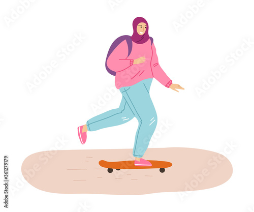 Young smiling muslim woman in hijab enjoying skateboarding outdoors