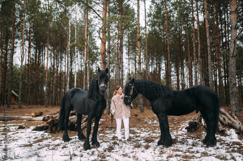 Beautiful girl with her Andalusian horse in the winter forest © benevolente