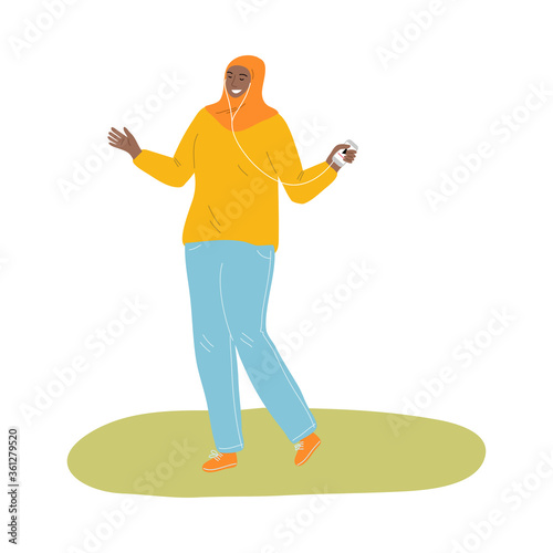 Young muslim woman in hijab and sport clothing listening to music