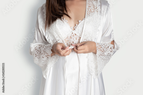 Schilderij op canvas Phetchaburi / Thailand - June 27 2020 Women wearing white nightgown & long sleeve satin robe with floral lace, A girl trying on new white nightwear for sleep