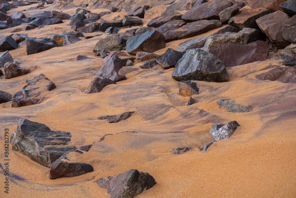 natural filled frame close up wallpaper background early morning photo of sharp brown black rocks on a wet yellow orange sand beach. Sri Lanka natural filled frame close up wallpaper background early morning photo of sharp brown black rocks on a wet yellow orange sand beach. Sri Lanka