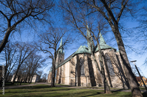 Obraz na plátně Linköping Cathedral in Swedish town Linkoping with blue sky and trees