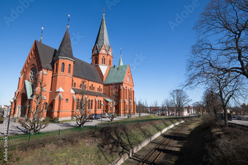 The Sankt Petri Kyrka or Saint Peter Church next to the metro line in Västervik (Vastervik) in Sweden. Blue sky