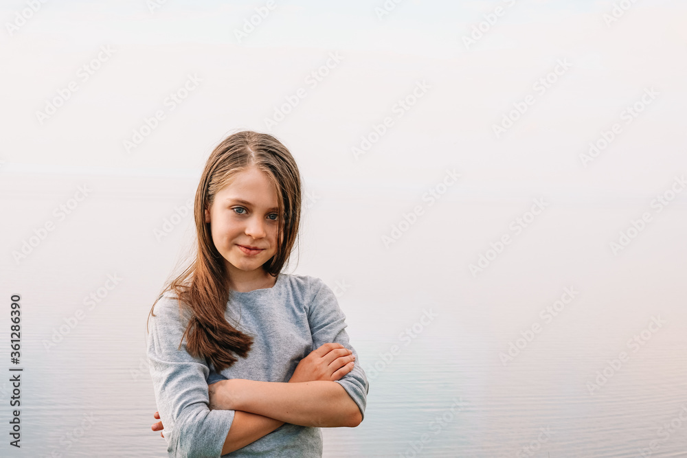 Portrait of a 10-year-old girl child in business style, arms crossed on her chest