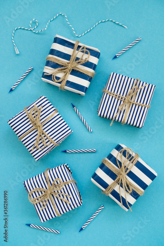 Holiday gifts decorated with striped paper on a blue background
