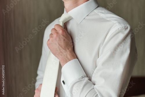 man tightens his tie, white tie, wedding day, man in a white shirt, groom fees, White shirt