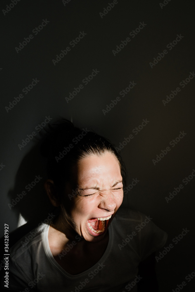 Caucasian woman screaming in sunlight. Black shadows. Mental health Caucasian woman screaming in sunlight. Black shadows. Mental health