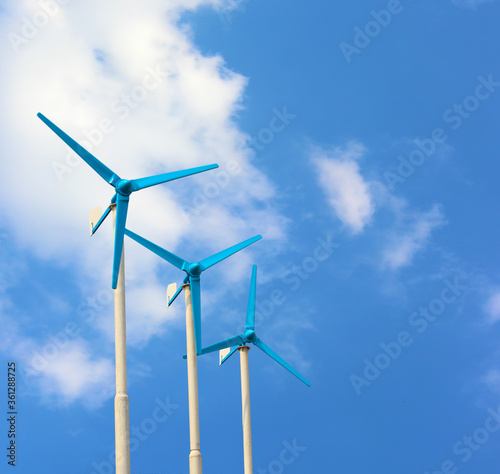 Three wind turbine generating electricity on blue sky