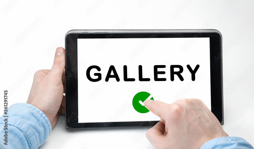 Male hands holding tablet pc with text GALLERY on white background Male hands holding tablet pc with text GALLERY on white background