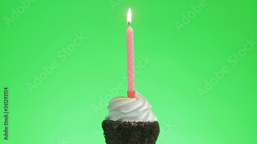 Lighting a blue candle on a delicious cupcake, green screen