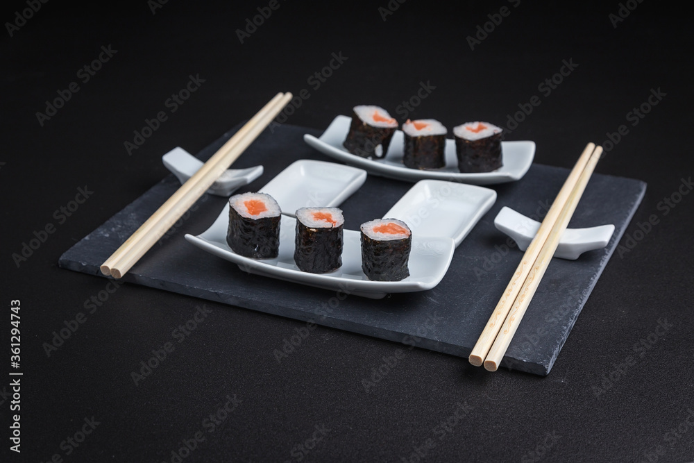 Set of traditional japanese food on a dark background. Sushi rolls. Asian food frame. Dinner party. 